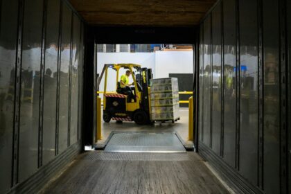 A forklift moving a pallet, the single highest-risk step in warehouse material handling for equipment distributors