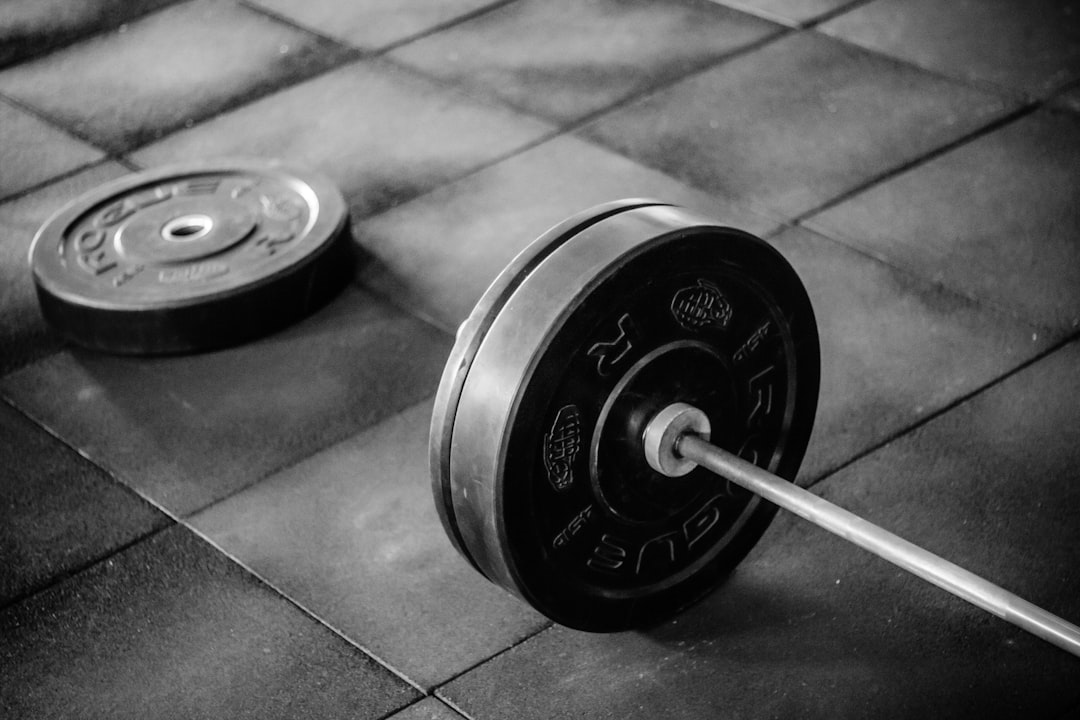 A loaded barbell on tile, the concentrated point load that gym floor load capacity has to absorb
