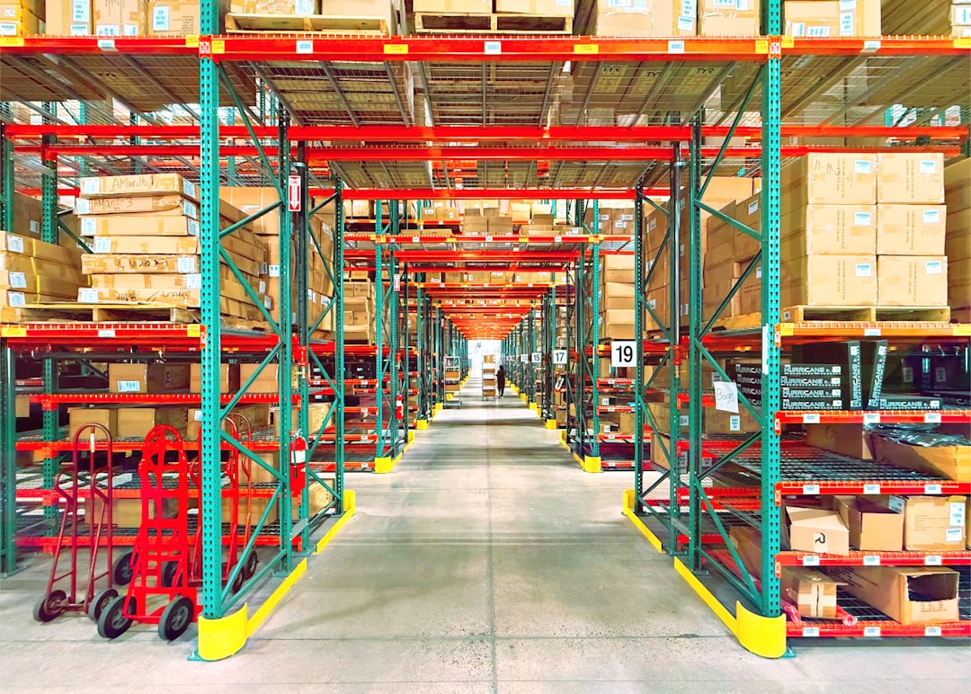 A long racking aisle where clearance signs and aisle width decide warehouse material handling safety