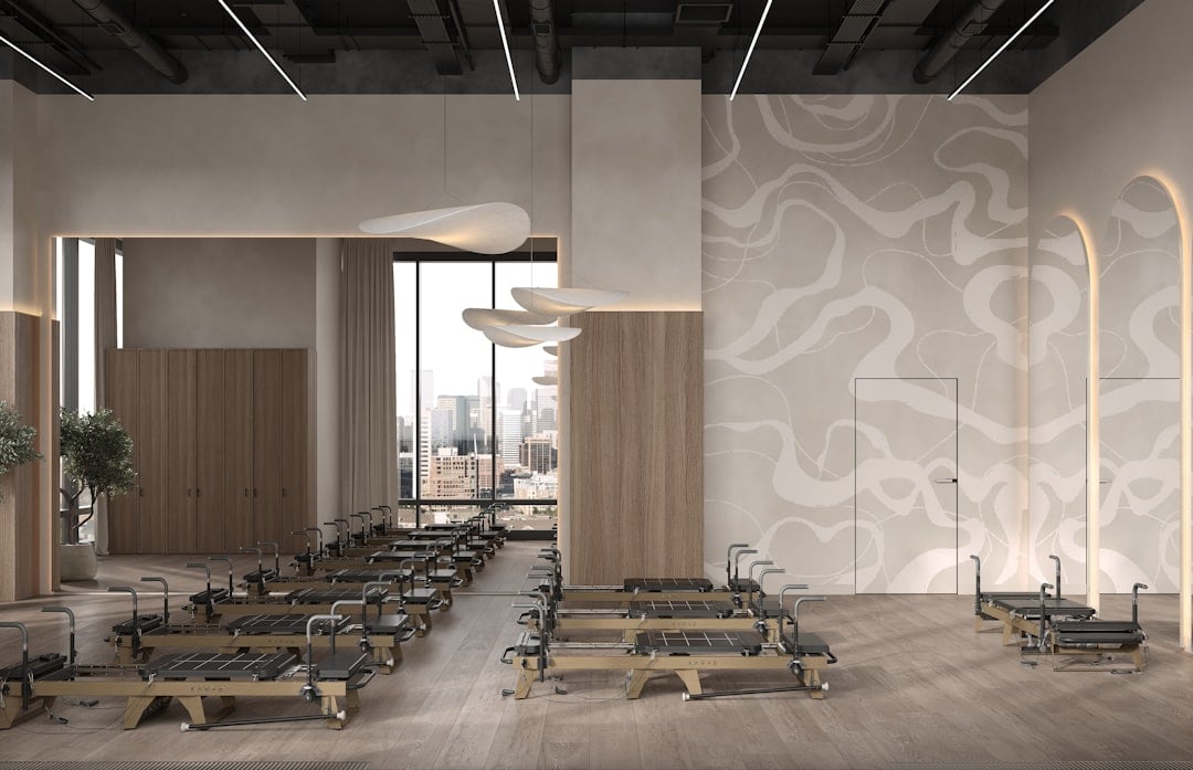 Studio interior where commercial pilates reformers are inspected between client blocks