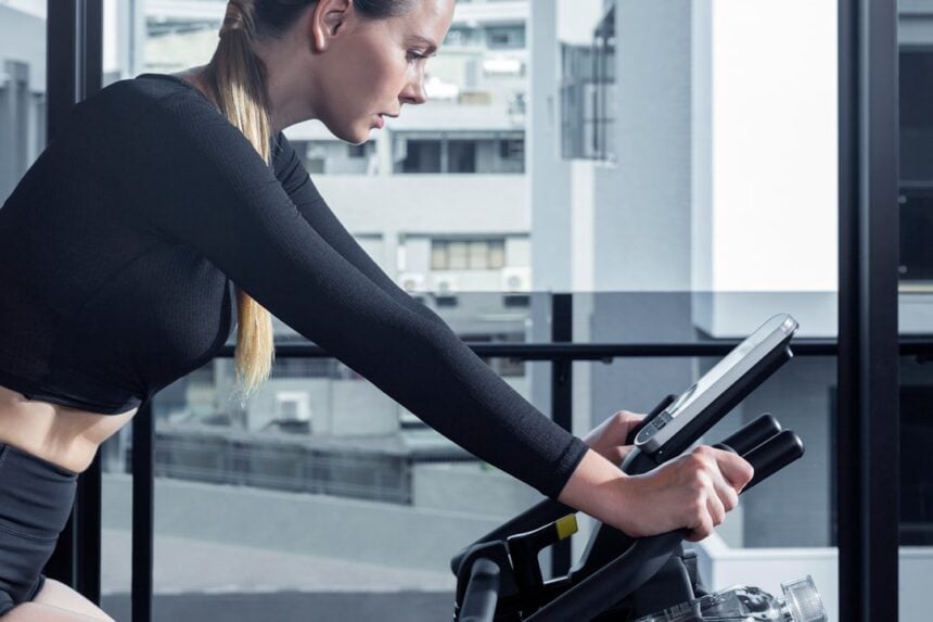 Studio rider on one of a fleet of group cycle bikes during a scheduled class