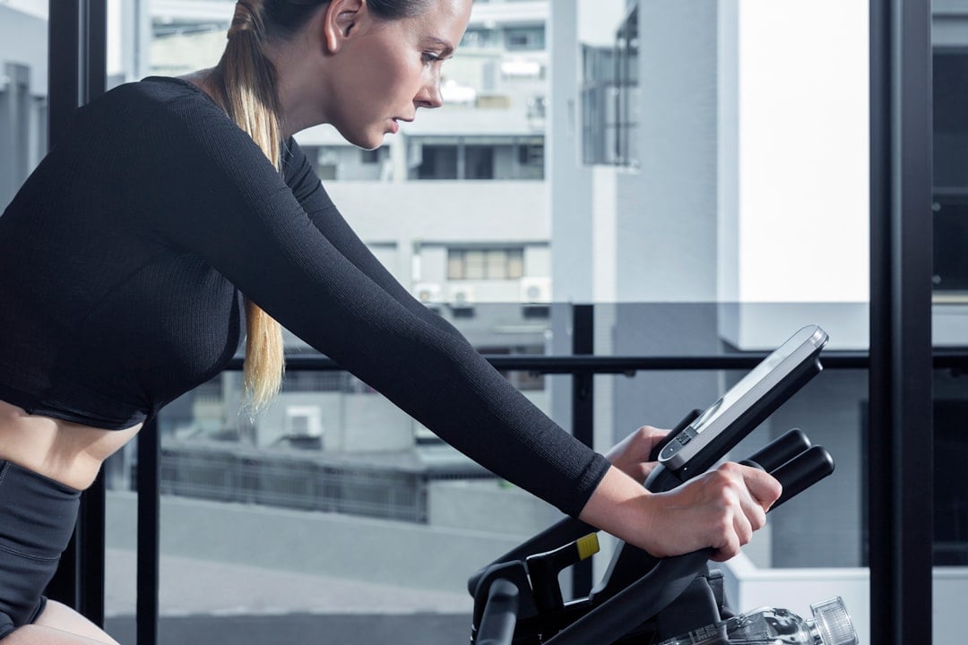 Studio rider on one of a fleet of group cycle bikes during a scheduled class