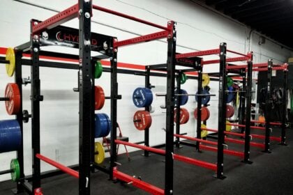 Row of squat racks illustrating an equipment model changeover on a club strength floor