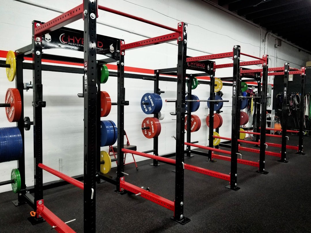 A row of squat racks sized against fitness facility foot traffic at peak hours