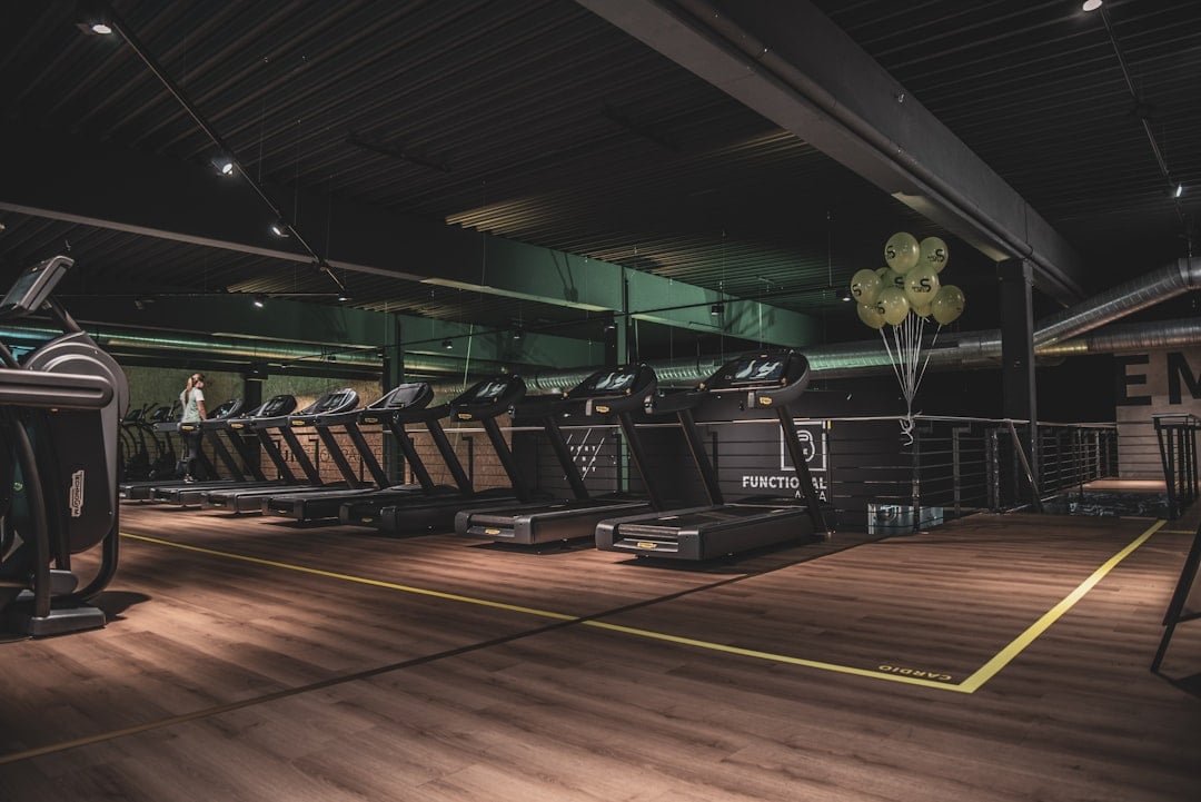 Treadmill row on an empty floor, the window when gym equipment firmware updates get staged