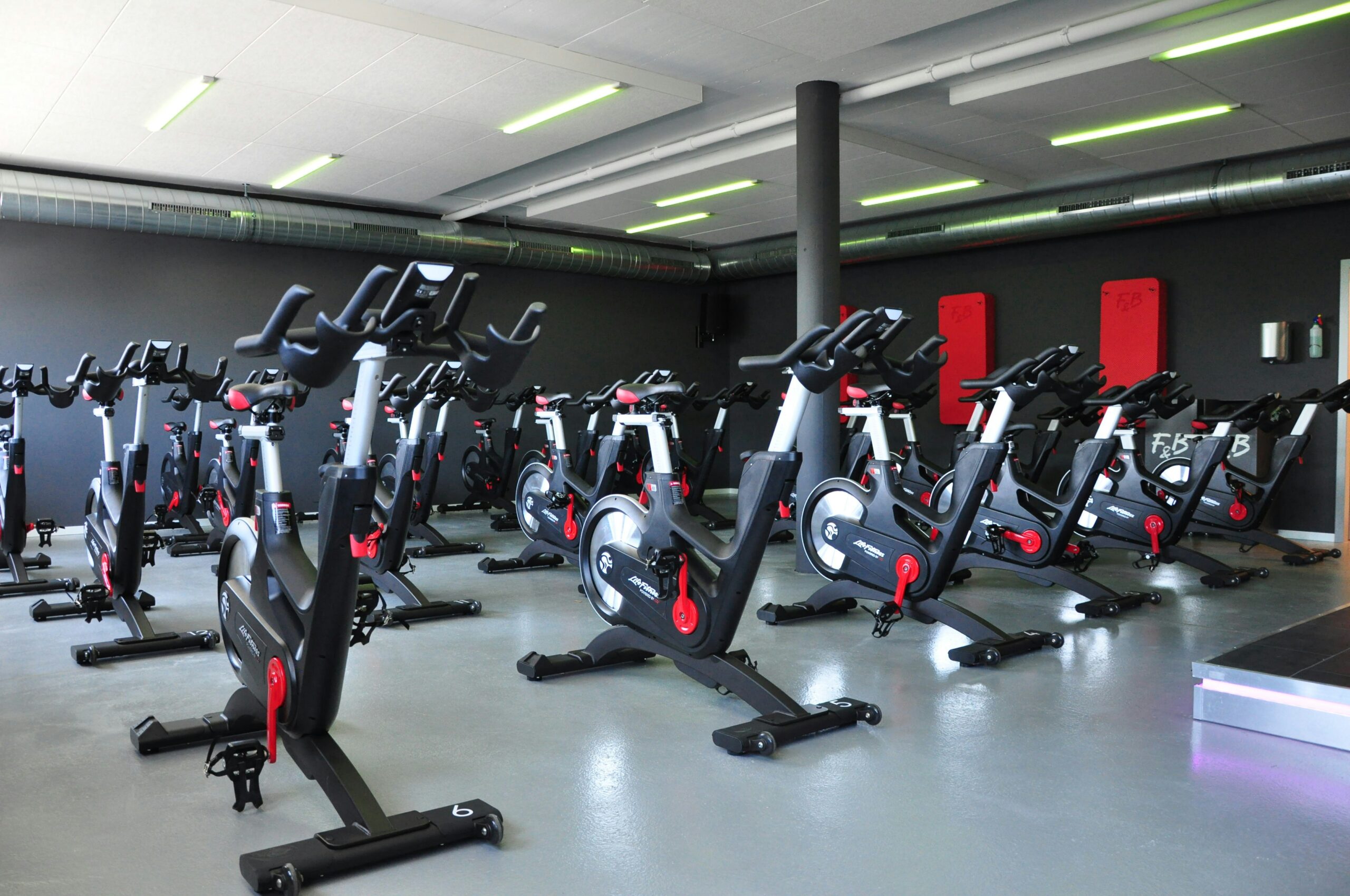 Stationary bikes in a studio, a common entry point for self-powered cardio equipment on a club floor